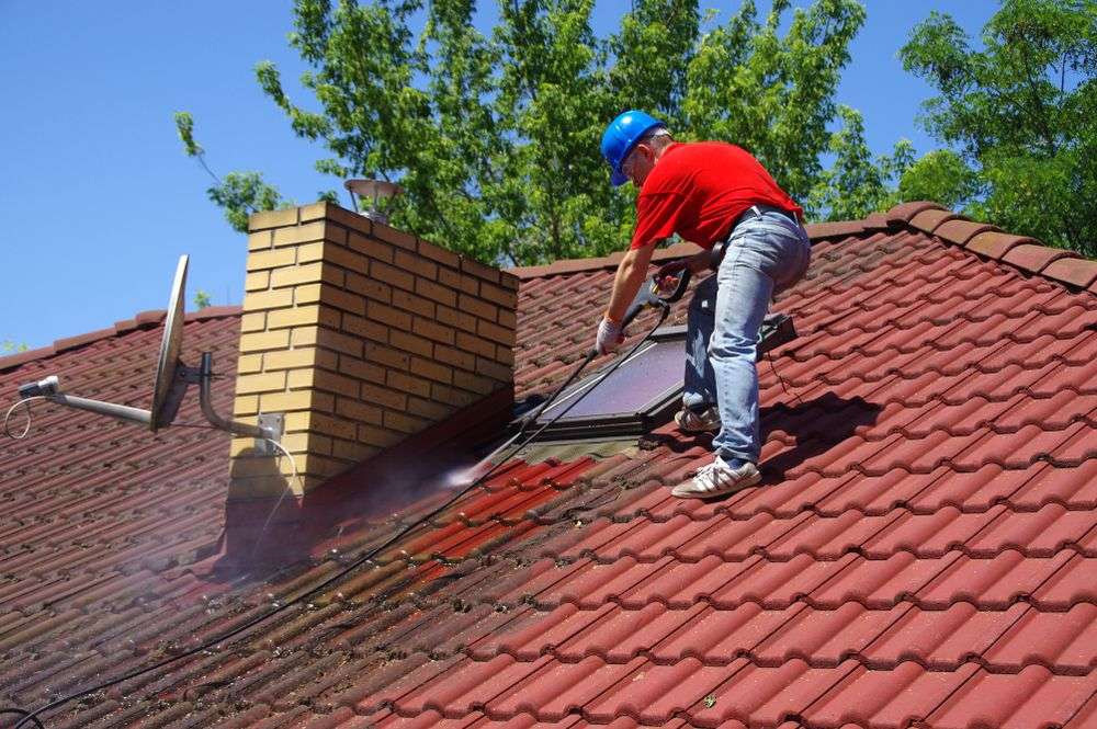 Schoonspuiten van de dakpannen in Heemskerk